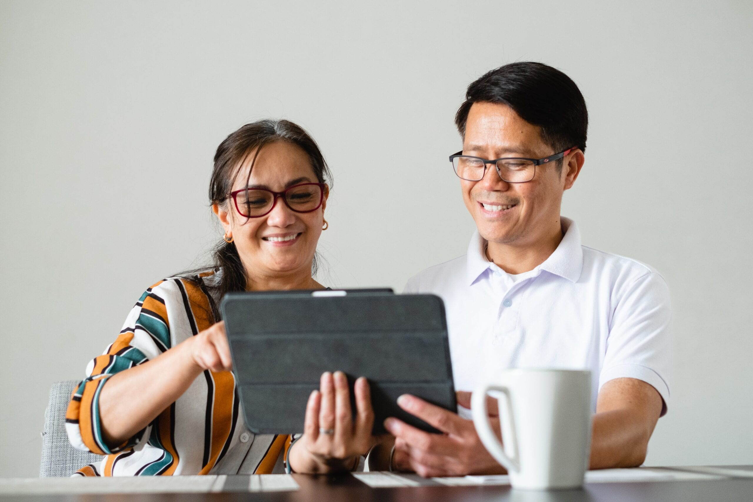 couple-smile-as-the-use-a-tablet